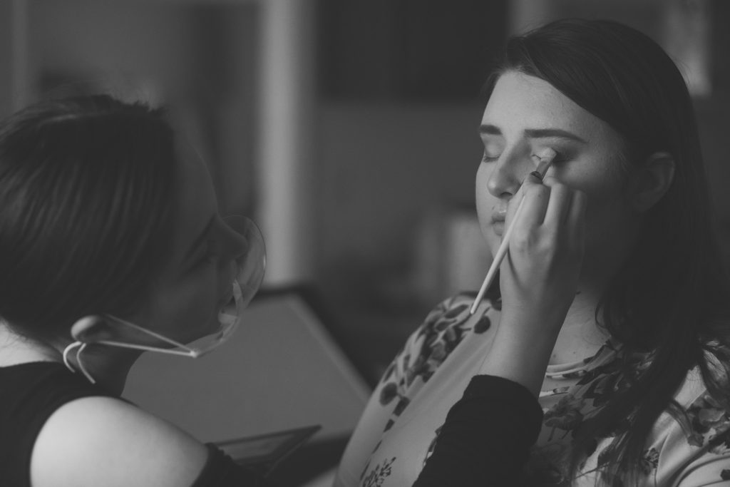 Boudoir makeup in black and white with makeup artist doing eyeshadow